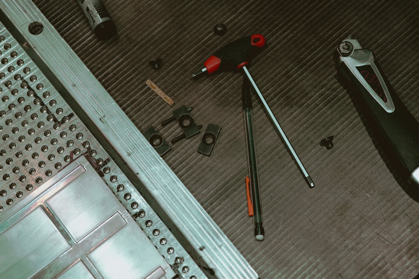 Verschiedene Werkzeuge und Metallteile auf einer Werkbank.