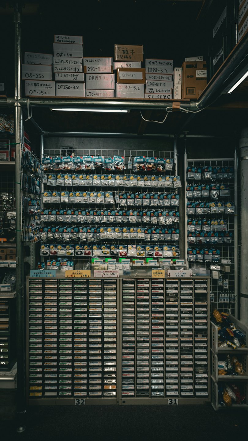 Kleine Elektronikteile in Plastiktüten auf einem Lochwandsystem.